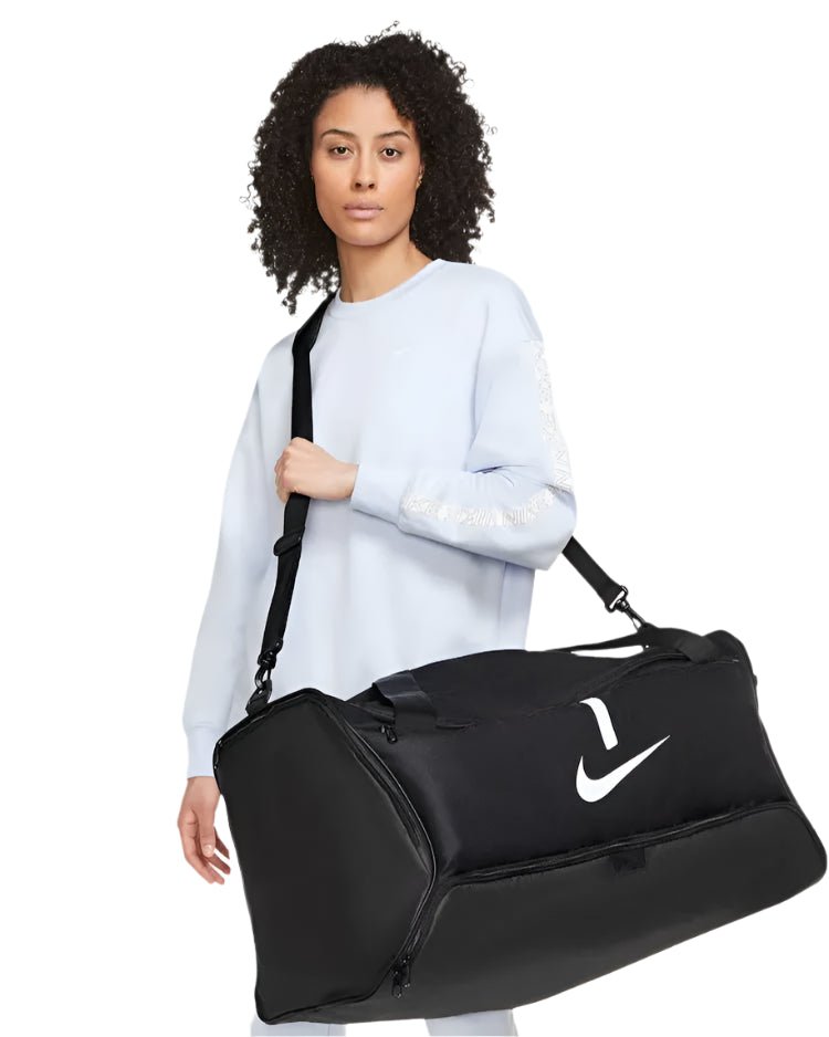 Female model showcasing Nike Brasilia Medium Training Duffel Bag in black